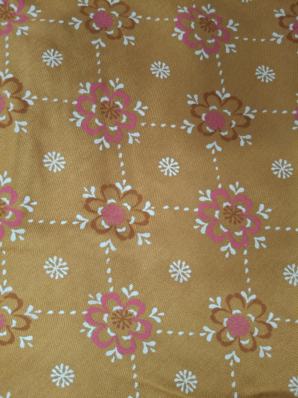 Close-up of floral block print fabric detail on Miss Kapachi mustard yellow dress