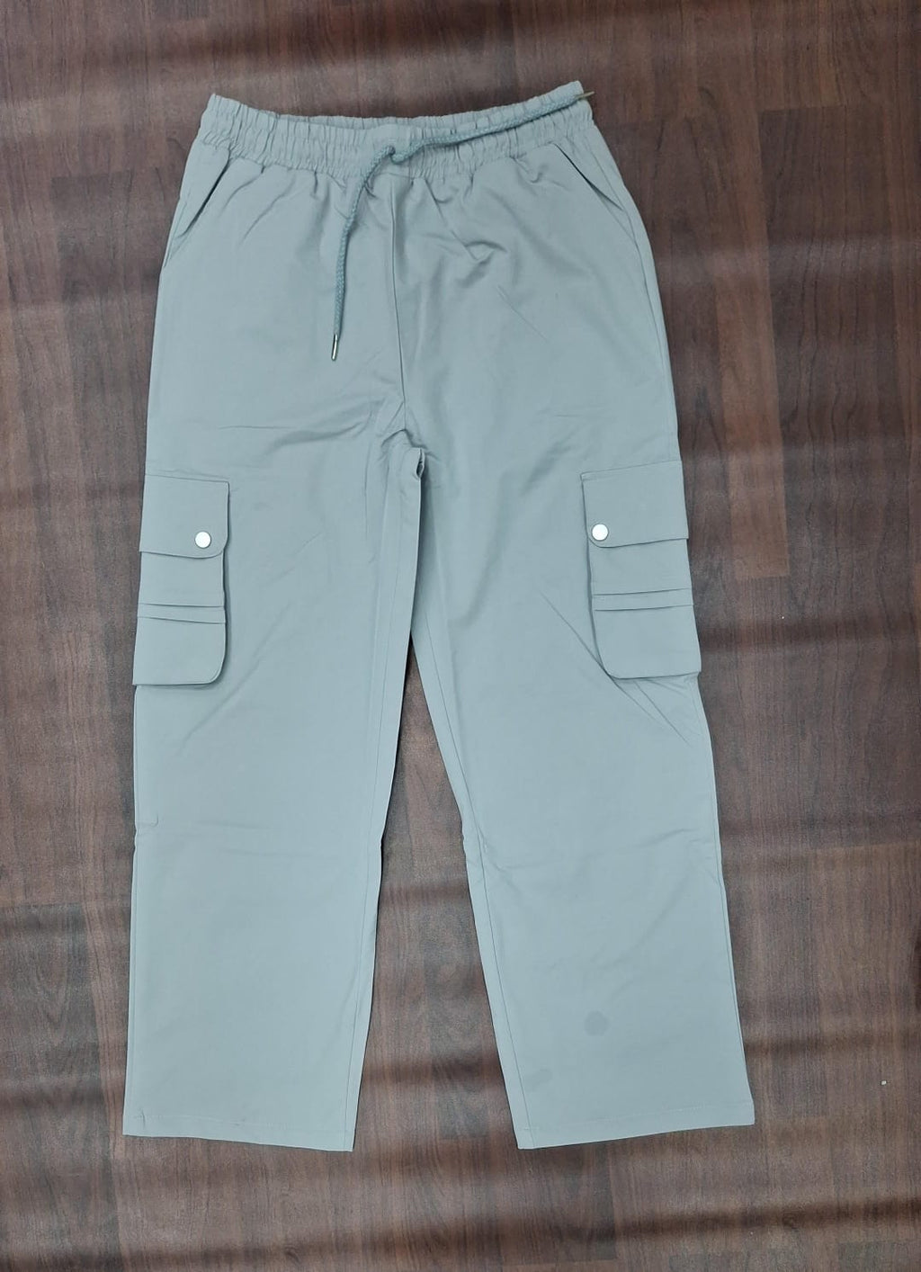 Black relaxed-fit cargo pants with elasticated drawstring waist and snap-button cargo pockets
