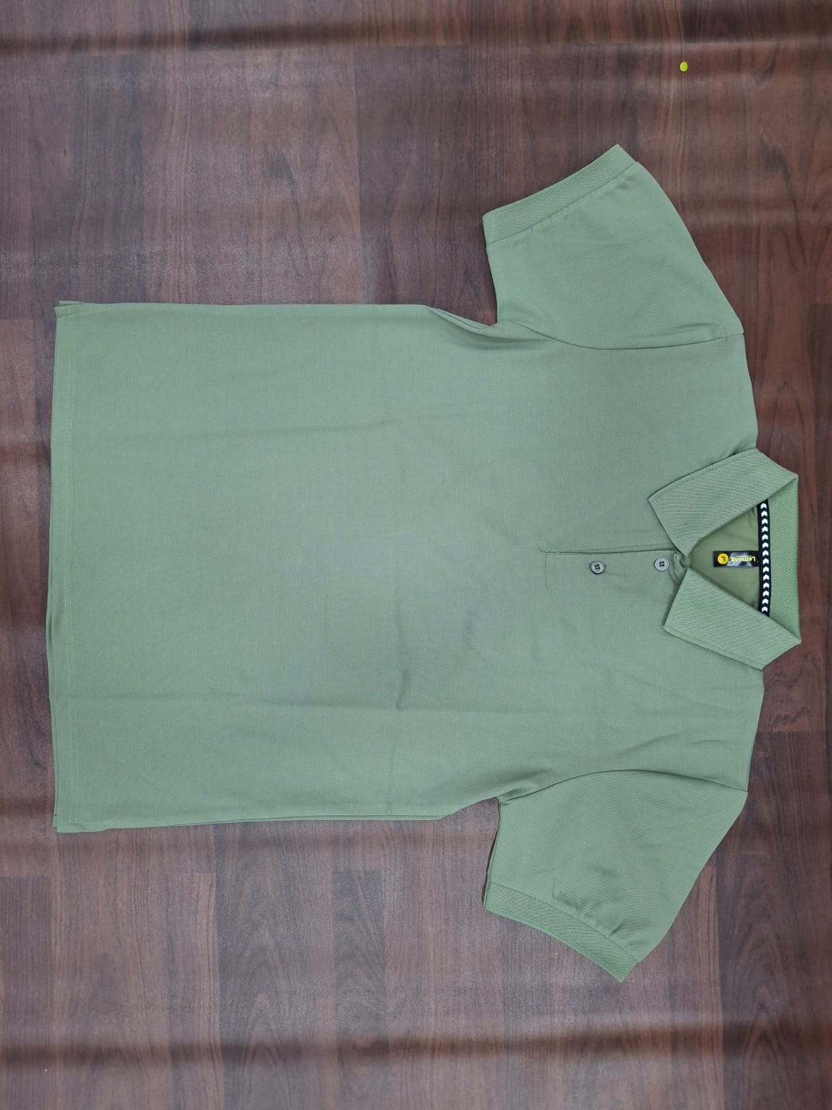 Sage green solid half-sleeve polo T-shirt with structured collar, two-button placket, and contrast trim